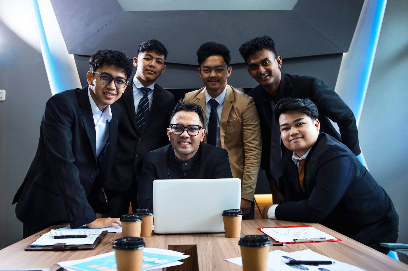 Indonesian professionals reviewing a plan together on a laptop