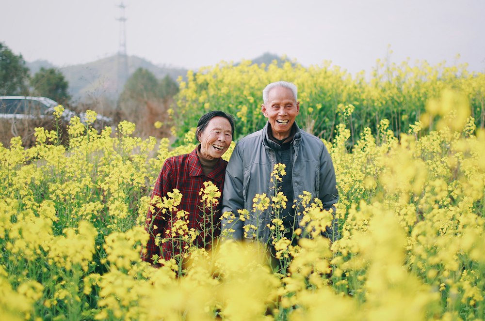 An older couple laughing in a field of flowers