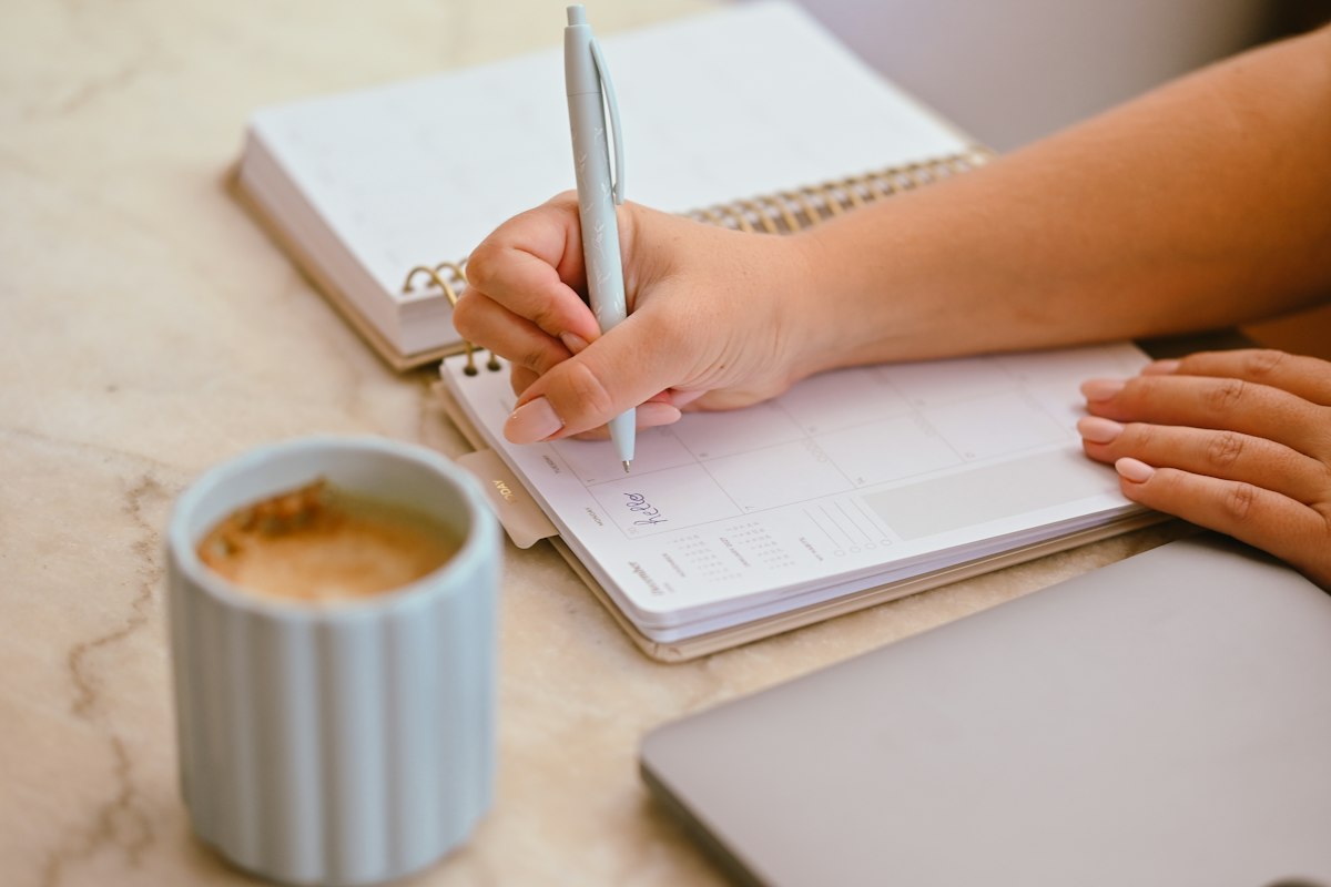 A planner and coffee on a desk